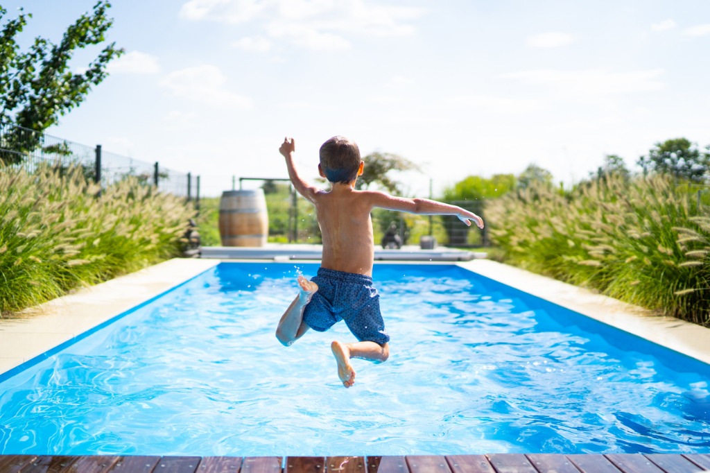 Boy jumping in a blue pool